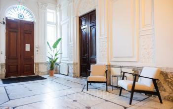 Elegant interior with high ceilings and detailed moldings at Keizersgracht 452, Amsterdam Canal Belt. Featuring comfortable seating, the space is ideal for welcoming clients in a prestigious setting. Perfect for office space rental.