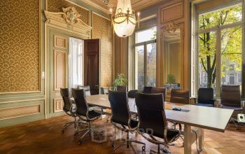 Elegant conference room at Keizersgracht 452 with classic decor, large windows, and ergonomic chairs around a long table.