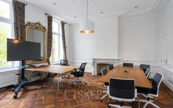 Spacious meeting room with large windows and ornate mirror at Keizersgracht 452, Amsterdam Canal Belt. Ideal office space rental.