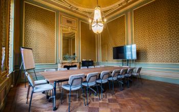 Elegant conference room with ornate walls, chandelier, large table, and chairs, perfect for office space rental on Keizersgracht 452, Amsterdam Canal Belt.