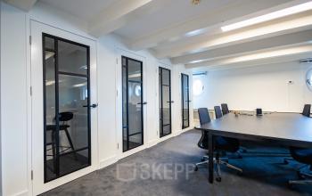 Spacious open-plan office for rent at Keizersgracht 452, Amsterdam Canal Belt, featuring modern design with sleek glass partitions and ample natural light.