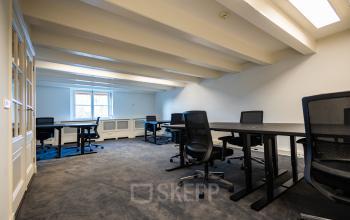 Modern office space available for rent at Keizersgracht 452 in Amsterdam Canal Belt, featuring ergonomic chairs, spacious desks, and ample natural light from the windows.