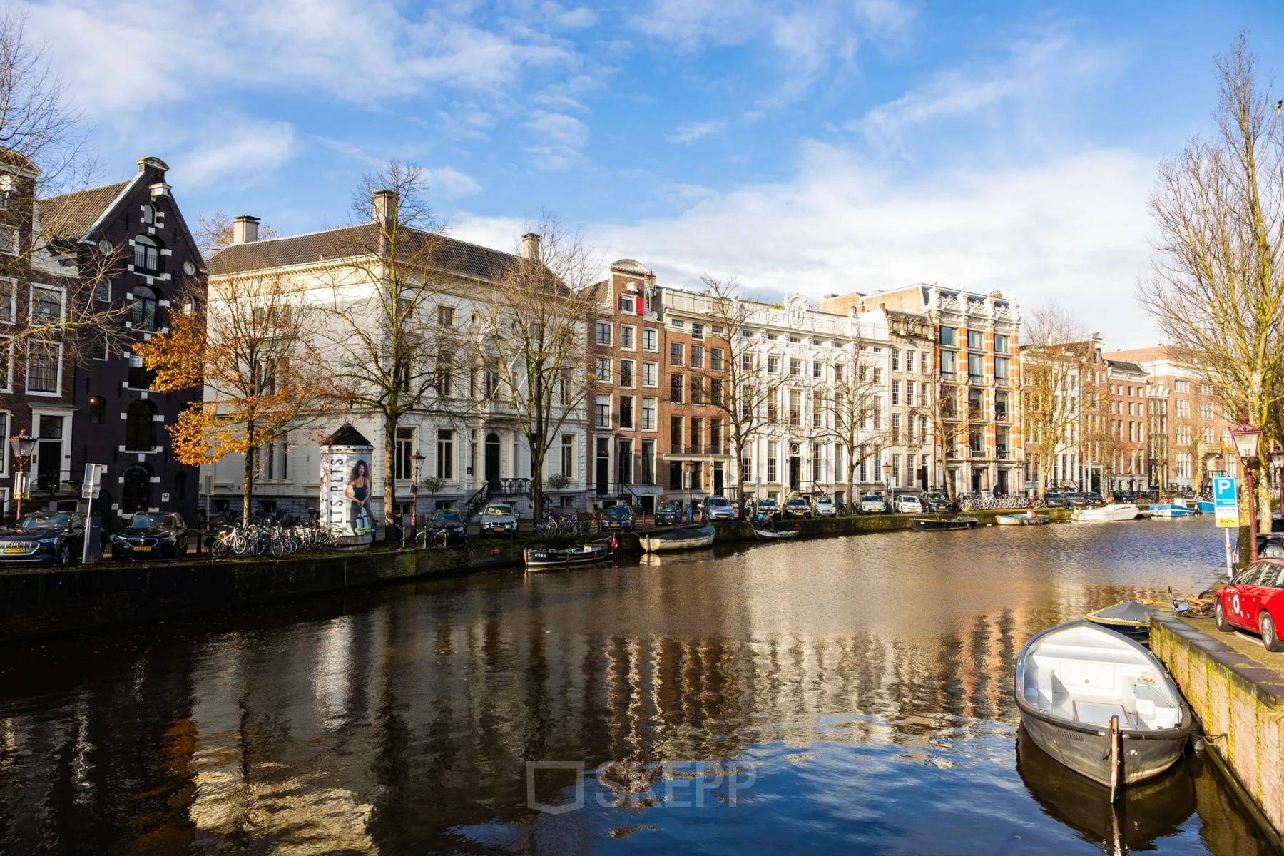 A scenic view of the Amsterdam Canal Belt at Keizersgracht 452, showcasing historic buildings along the water.