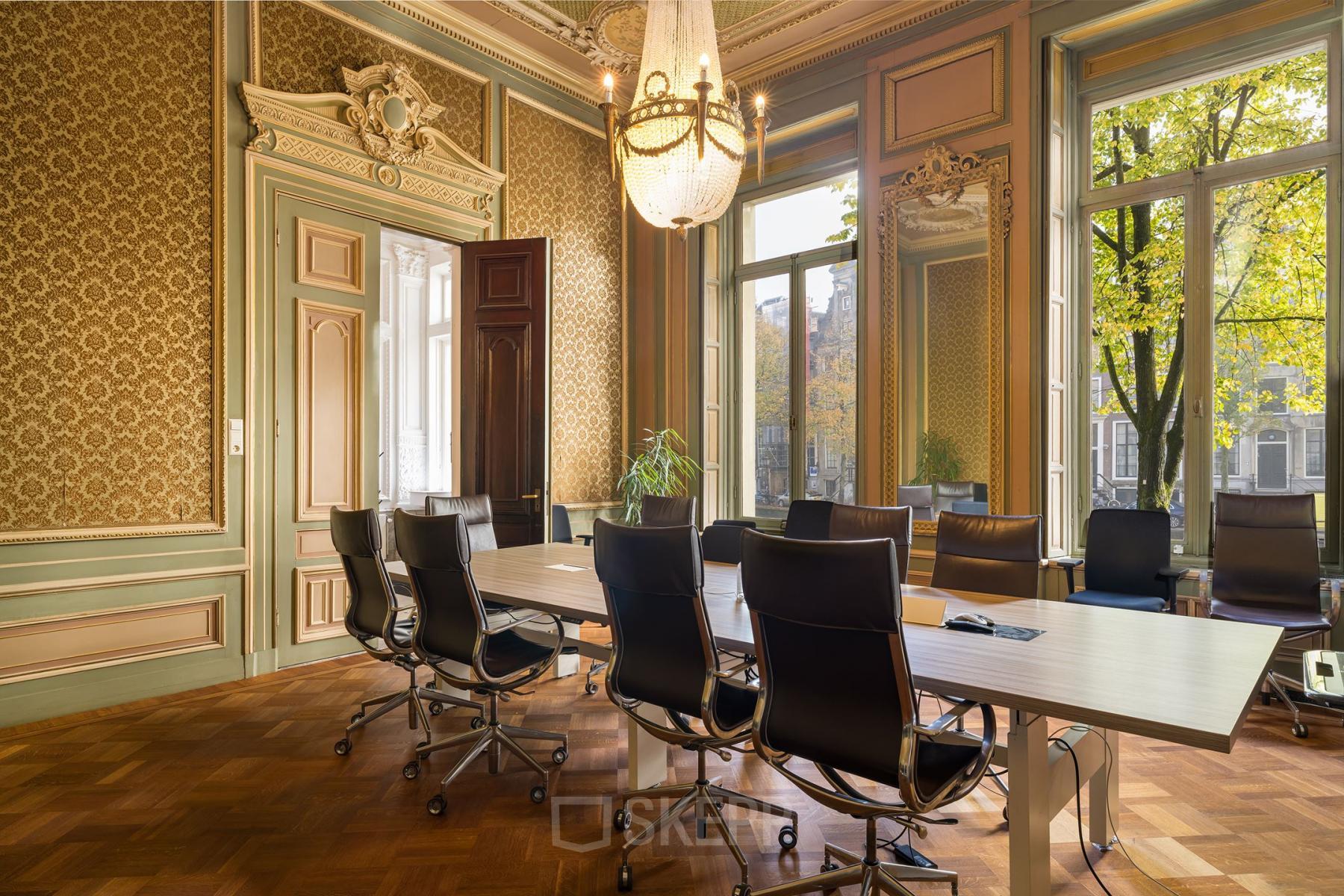 Elegant conference room at Keizersgracht 452 with classic decor, large windows, and ergonomic chairs around a long table.