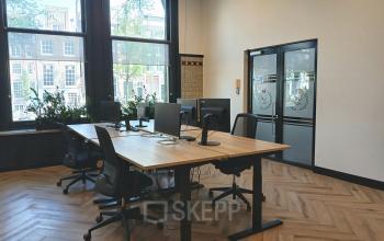 Bright office at Herengracht 320 with wooden floors, modern furniture, and large windows offering views of Amsterdam Canal Belt. Perfect office space rental for productivity.