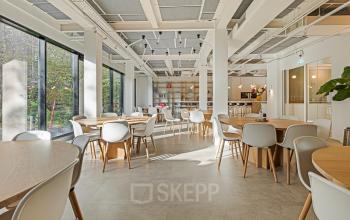 Spacious office space rental at Keizersgracht 572 572, Amsterdam's Canal Belt, featuring modern furnishings and large windows offering natural light, perfect for collaborative work environments.