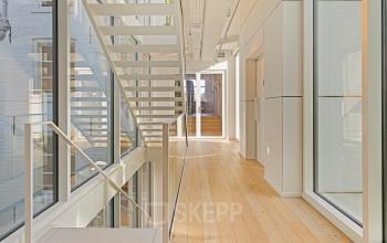 Bright, spacious hallway with wooden flooring and glass walls in office building at Keizersgracht 572 572, Amsterdam Canal Belt. Ideal for office space rental, offering a modern and professional environment.