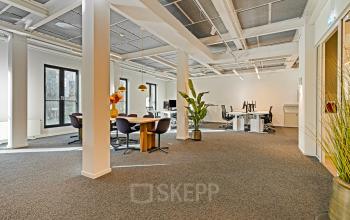 Spacious open floor plan with modern furnishings, located at Keizersgracht 572 572 in Amsterdam Canal Belt. Ideal for office space rental, featuring multiple workstations and a meeting area, flooded with natural light.