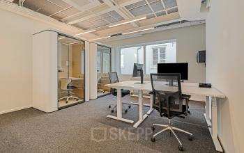 Bright office space rental at Keizersgracht 572, featuring modern desks, ergonomic chairs, and phone booths within the Amsterdam Canal Belt. Ideal for collaborative work in a well-lit, professional setting.