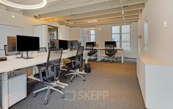 Modern interior office space rental at Keizersgracht 572 572 in Amsterdam, featuring an open floorplan with multiple desks, chairs, and large windows, equipped with technology and contemporary lighting.