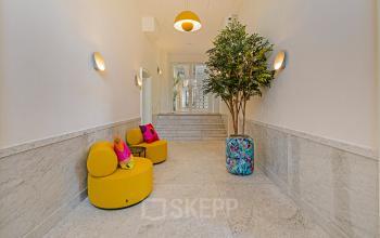 Bright entrance area with modern seating and decorative plants, creating a welcoming vibe for those seeking office space rental in the Amsterdam Canal Belt.