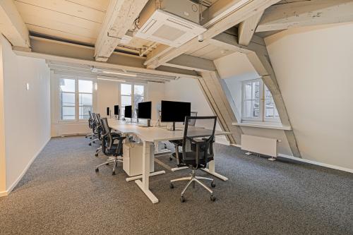 Modern office space in Amsterdam's Canal Belt at Keizersgracht 572. Features spacious workstations under wooden beams, offering a stylish setting for office space rental.