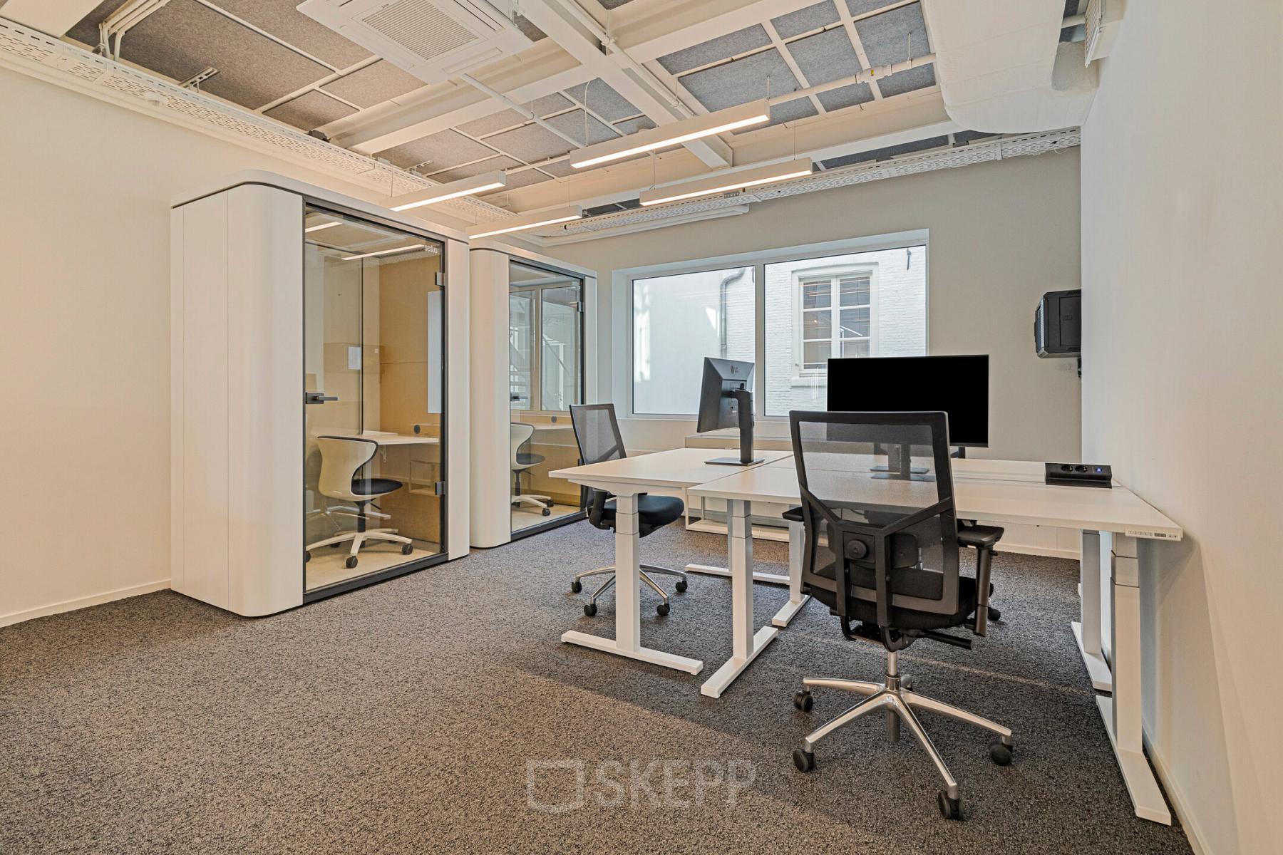 Bright office space rental at Keizersgracht 572, featuring modern desks, ergonomic chairs, and phone booths within the Amsterdam Canal Belt. Ideal for collaborative work in a well-lit, professional setting.
