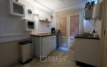 Compact kitchenette in the office to rent at Keizersgracht 391A, featuring modern appliances and white cabinetry blending with the charming Amsterdam Canal Belt setting.