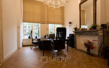 Charming office space rental on Keizersgracht 391A in Amsterdam Canal Belt with elegant interior, featuring wooden floors, chandelier lighting, and classic furnishings with a touch of modern style.