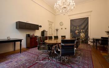 Elegant conference room at Keizersgracht 391A, Amsterdam Canal Belt, featuring a large wooden table, stylish chairs, and a chandelier, ideal for office space rental.