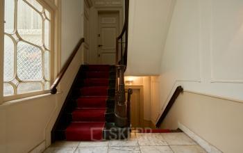 Staircase with red carpet in the interior of an office building at Keizersgracht 391A, Amsterdam Canal Belt, showcasing classic architectural details, ideal for office space rental.