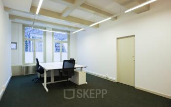 Bright office space with minimalist design at Keizersgracht 261, Amsterdam Canal Belt, featuring modern desks and chairs near large windows. Ideal for office space rental with natural light and a quiet atmosphere.