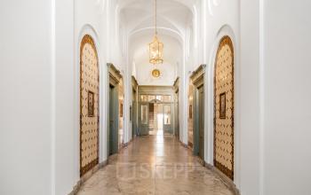 Elegant entrance hallway with classic arches, ornate chandeliers, and vintage decor details at Keizersgracht 261 in Amsterdam Canal Belt, ideal for office space rental.