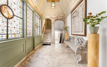 Elegant entrance space with marble flooring and ornate stained glass windows at office to rent on Keizersgracht 261, Amsterdam Canal Belt.