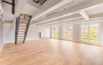 Spacious unfurnished office interior with wooden flooring and large windows at Herengracht 582-584, Amsterdam Canal Belt. Ideal for office space rental.