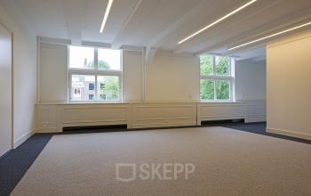 Interior view of office space available for rent at Herengracht 448-458, Amsterdam Canal Belt, featuring large windows and ample natural light.