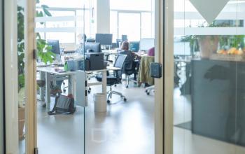 Modern office space at Singel 542, Amsterdam Canal Belt with people collaborating at workstations, available for office space rental.