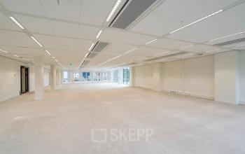 Spacious unfurnished office space available for rent at Herengracht in Amsterdam Canal Belt, featuring bright lighting and large windows.