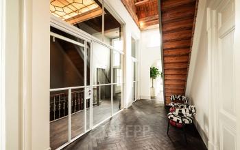 Spacious hallway with wooden floors and modern glass panels at Keizersgracht 264, ideal for businesses seeking office space rental in Amsterdam Canal Belt.