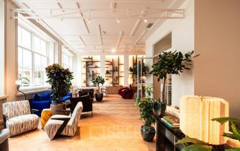 Furnished office space at Keizersgracht 264, Amsterdam Canal Belt, featuring stylish seating and large windows, available for rent.