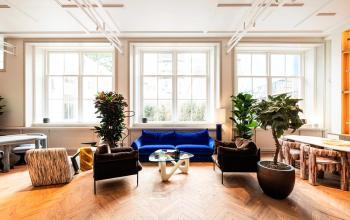 Bright and modern office space rental at Keizersgracht 264, Amsterdam Canal Belt, with a stylish seating area and large windows allowing natural light.