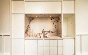 Chic kitchen area in an Amsterdam Canal Belt office with sleek marble countertops and modern fixtures, perfect for office space rental.