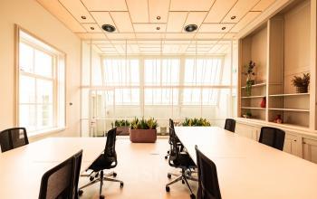 Bright office space with large windows, furnished with desks and chairs, perfect for workspace rental at Keizersgracht 264, Amsterdam Canal Belt.