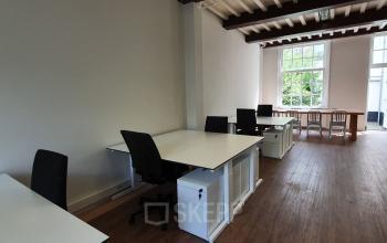 Bright office space at Keizersgracht 97-99 in Amsterdam Canal Belt features an open floorplan with multiple desks and chairs, ideal for collaborative work. Perfect for office space rental in a historic area.