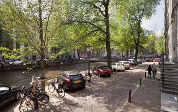 Beautiful office building located at Herengracht 495, Amsterdam Canal Belt, Amsterdam, showcasing picturesque canal walkways, parked cars, and tree-lined streets. Ideal for office space rental with scenic views.