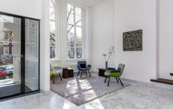 Modern office lobby at Keizersgracht 106, Amsterdam Canal Belt, with stylish furnishings and large windows offering natural light. Ideal office space rental.