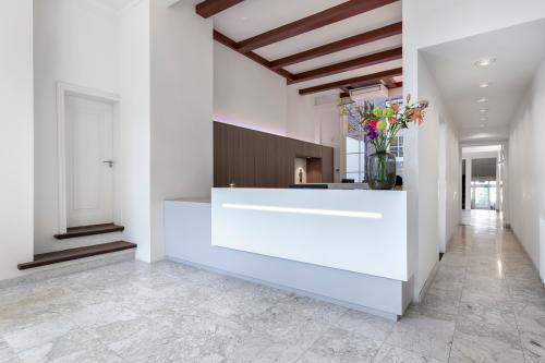 Modern reception area at Keizersgracht 106, Amsterdam Canal Belt, featuring a sleek desk, marble flooring, and a flower arrangement.