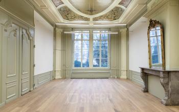 Elegant Herengracht 168 office space rental in Amsterdam Canal Belt, featuring high ceilings, large windows, and intricate moldings.