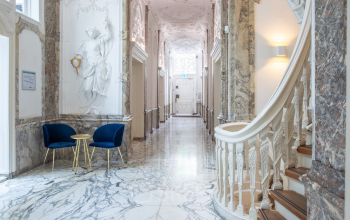 Elegant corridor within Herengracht 168 office space rental in Amsterdam Canal Belt with statues and grand staircase