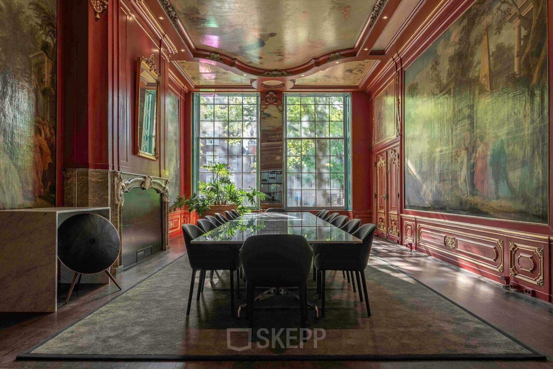 Elegant Amsterdam office space for rent at Herengracht 168 with a grand meeting table, ornate walls, and large windows offering views of the Canal Belt.