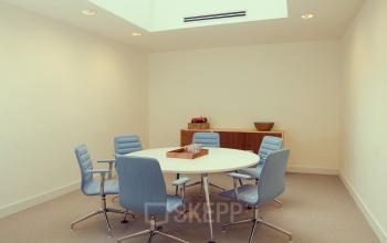 Modern, well-lit office space rental at Herengracht 124-128 in Amsterdam Canal Belt, featuring a round table with chairs and a welcoming ambiance.