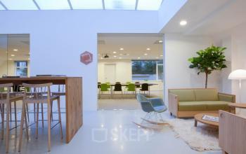 Modern office space rental at Herengracht 124-128 in Amsterdam Canal Belt, featuring comfortable furnishings and a chic lounge area.