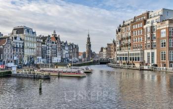 View of the Amsterdam Canal Belt with historical buildings and moored boats near office space rental at Amstel 62.