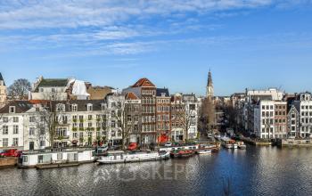 View of the Amsterdam Canal Belt with historical buildings along Amstel 62, ideal for those looking to rent office space.