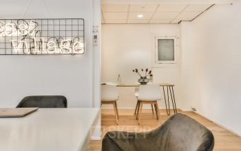 Modern office space rental at Amstel 62, Amsterdam Canal Belt, with a well-lit meeting area and stylish decor.