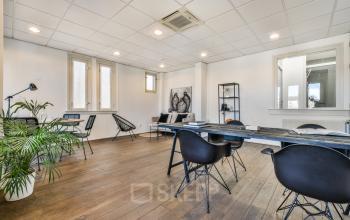 Modern office space rental at Amstel 62, Amsterdam Canal Belt, with large windows, hardwood floors, and contemporary furnishings.