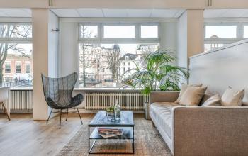 Modern and airy office space rental at Amstel 62, Amsterdam Canal Belt, with a comfortable lounge area overlooking the canal.