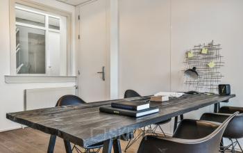 Modestly appointed office space rental at Amstel 62, Amsterdam Canal Belt, with a large wooden table and chairs.