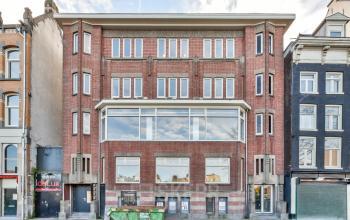 Modern office space rental at Amstel 62, situated in Amsterdam Canal Belt, with large windows overlooking the canal.