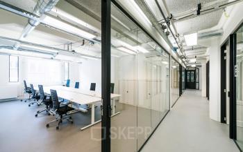 Modern office space with large glass partitions, sleek desks, and ergonomic chairs for rent in Amsterdam Houthavens.